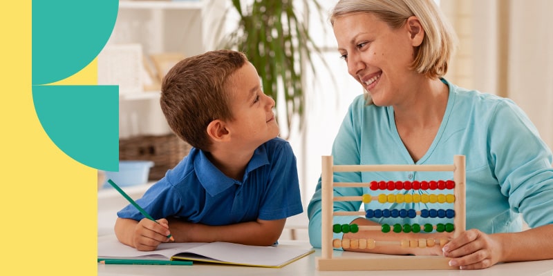 Instructor sits next to an abacus wile she assists a student in becoming a critical thinker for kindergarten.